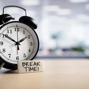 Break time concept message with alarm clock on desk in office